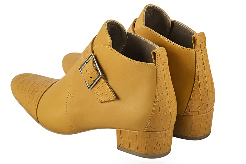 Mustard yellow women's ankle boots with buckles at the front. Round toe. Low block heels. Rear view - Florence KOOIJMAN